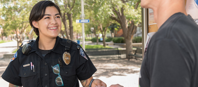 police officer talks to a student on campus